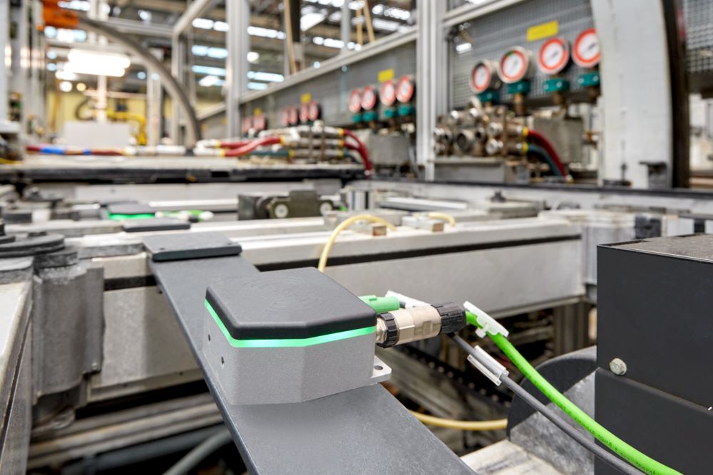 A NearFi coupler for contactless communication is located at each processing station and on each workpiece carrier